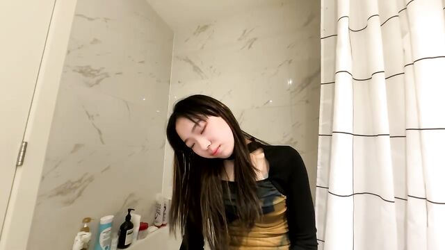 Cute petite Asian girl gives a full striptease